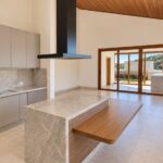 Ilha da cozinha com bancada em madeira da casa térrea no Condomínio Alto do Sion, Atibaia