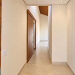 Corredor com porta pivotante da casa térrea no Condomínio Alto do Sion, Atibaia